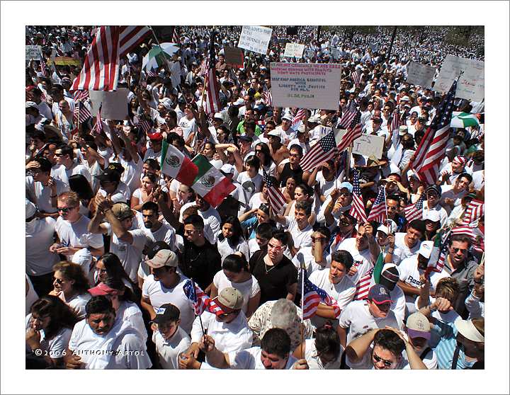 People holding Mexican Flags, American Flags and immigration banners